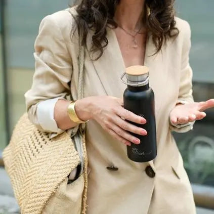 A women Holding balack Smart Hydration Flask water bottle