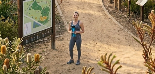 Active mum in Australia holding a smart water bottle during outdoor workout, ideal Mother’s Day fitness gift