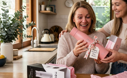 Emotional mother receiving a pink SmartFlask gift from her daughter in a sunlit Australian kitchen for Mother's Day.